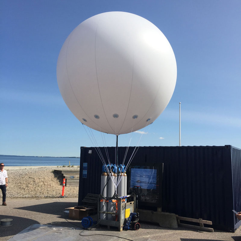 Large white helium balloon tethered outdoors