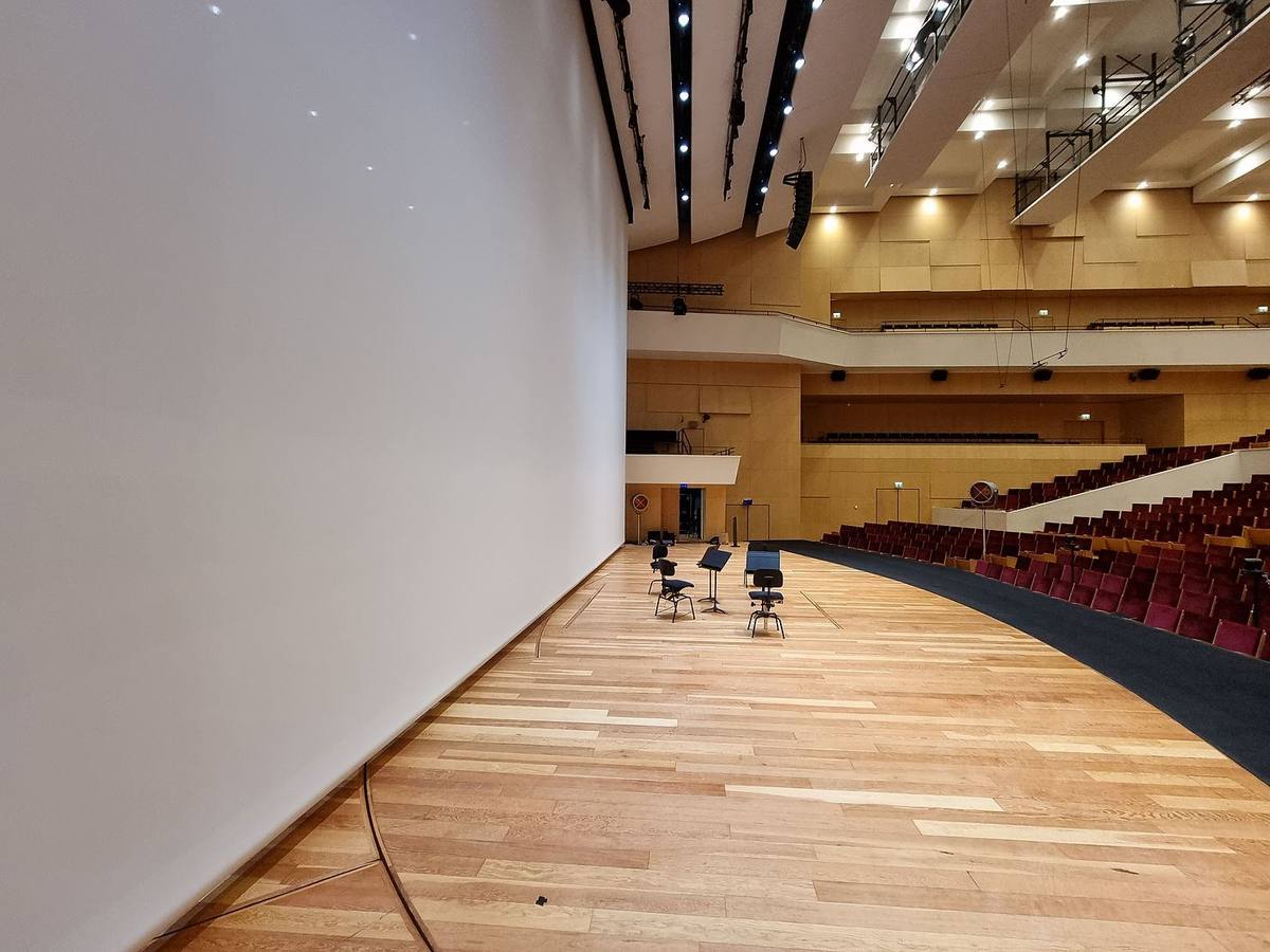 Écran de projection blanc installé dans une salle de concert