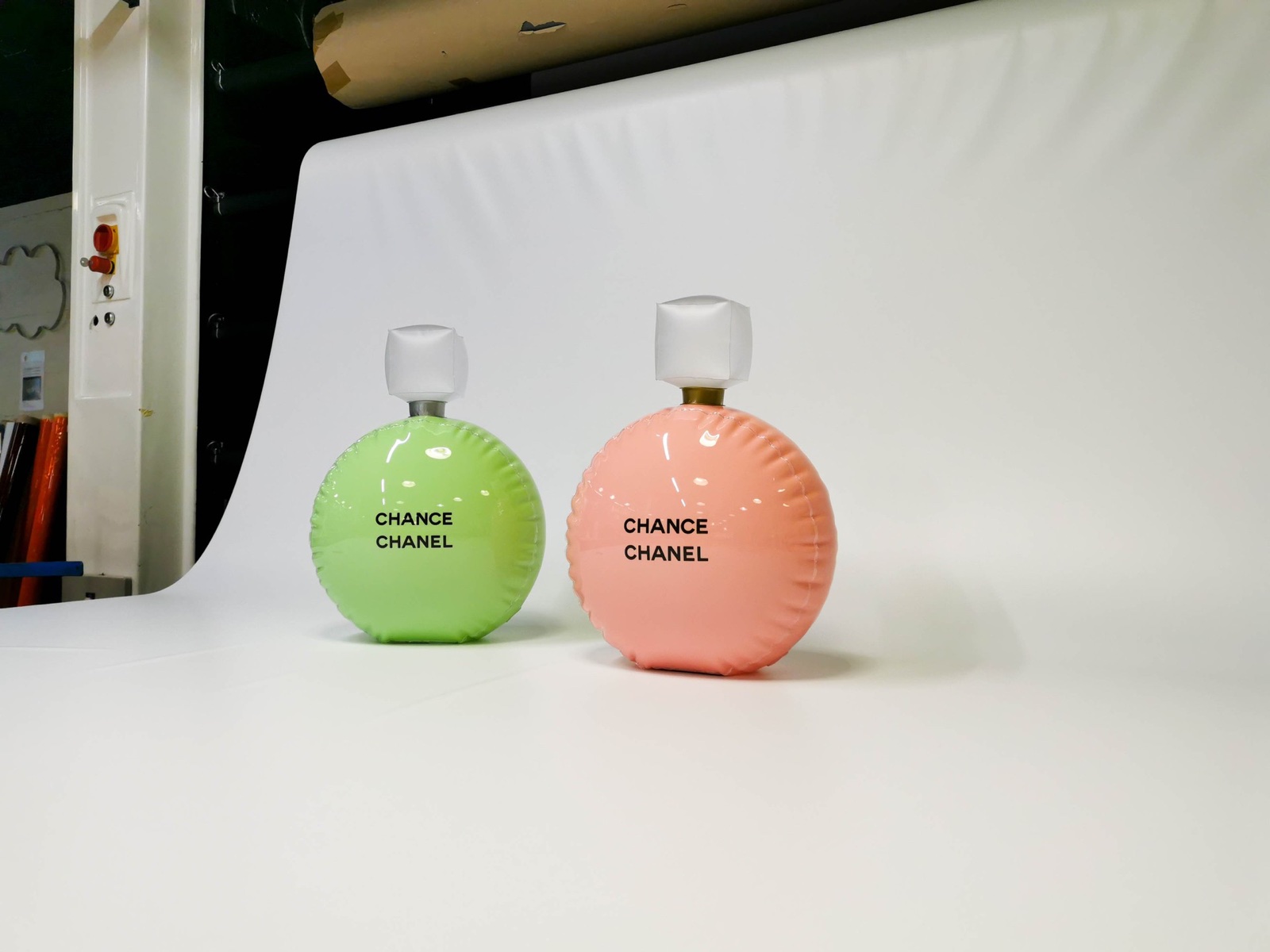 Répliques gonflables rose et verte des flacons Chanel Chance sur fond blanc