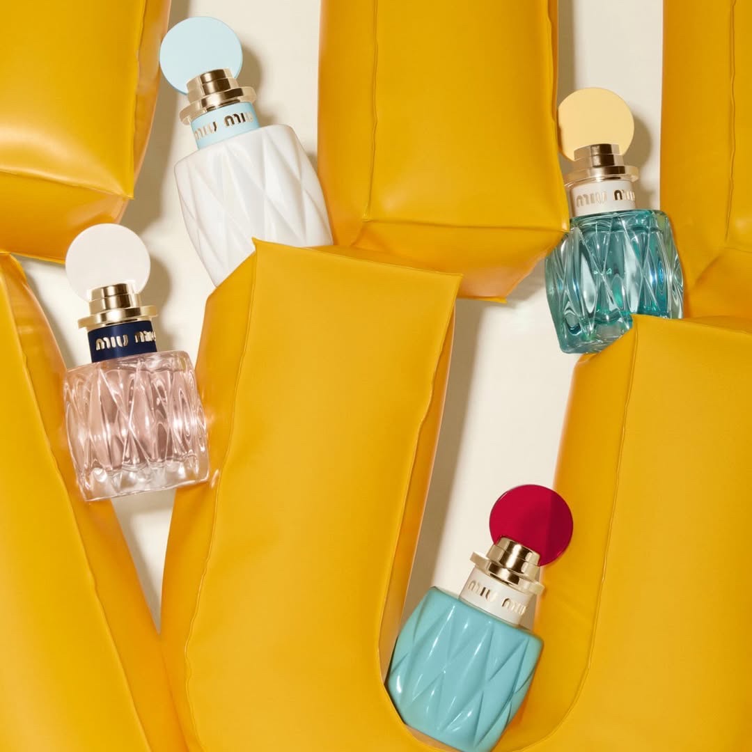 Parfums Miu Miu mis en scène parmi des éléments gonflables jaunes